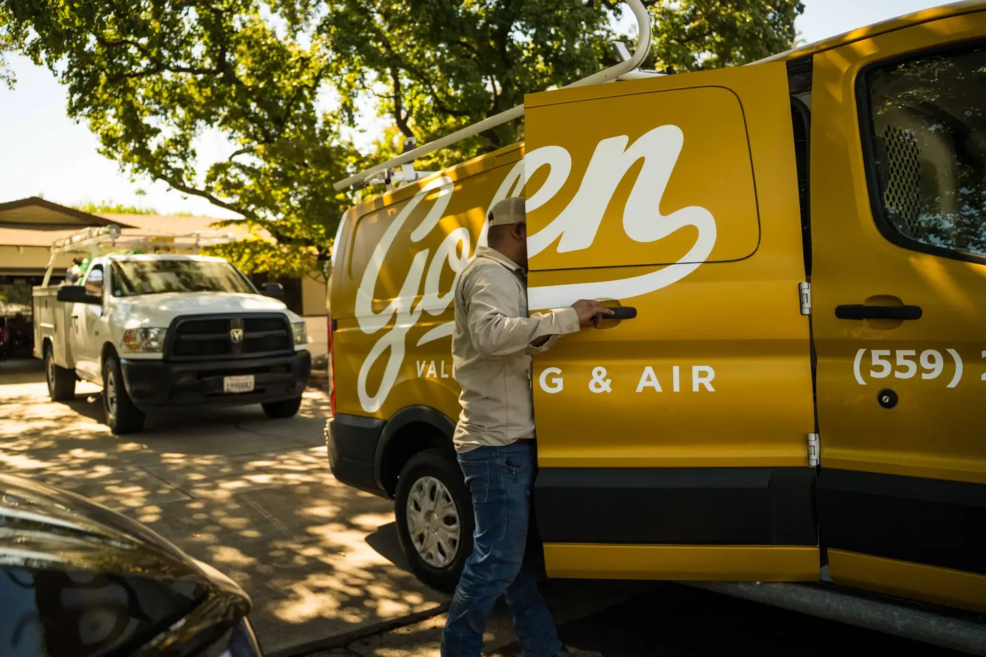 Golden Valley Heating and Air technician opening a Golden Valley service van at a Central Valley home